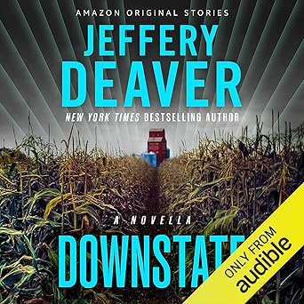 Cover of the audiobook "Downstate: A Novella" by Jeffery Deaver, an Amazon Original Story. The image shows a cornfield with a narrow path leading to a red barn in the distance, under dramatic lighting. The author’s name appears in large blue text at the top, and the title "Downstate" is in blue at the bottom. A yellow diagonal banner in the lower right corner reads "Only from Audible."